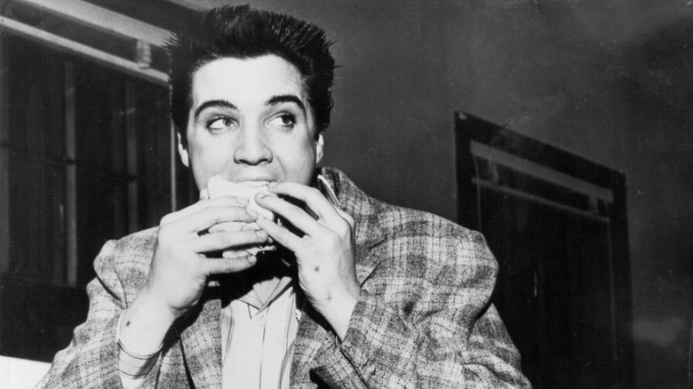 Elvis Presley eating a sandwich