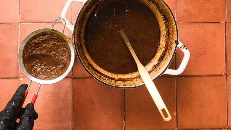 Pouring consomme through sieve