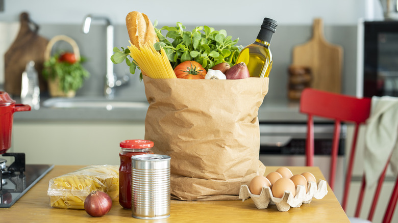 Brown bag full of groceries on kitchen table