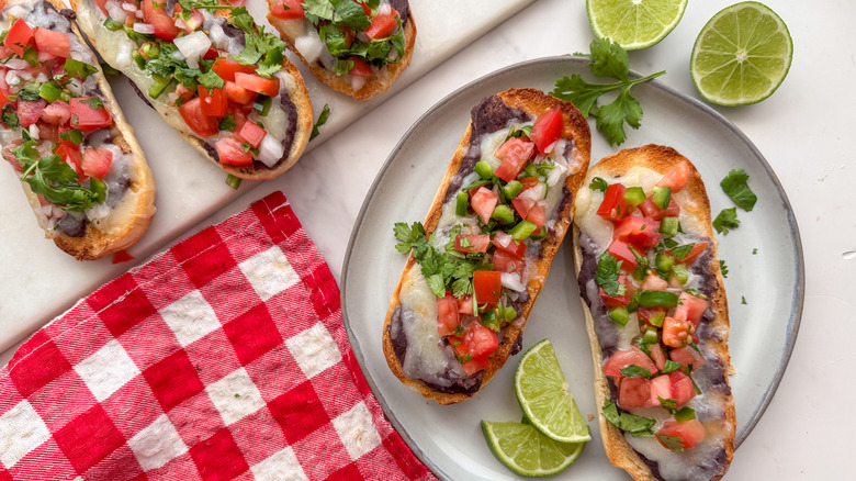 Molletes topped with pico de gallo on plate