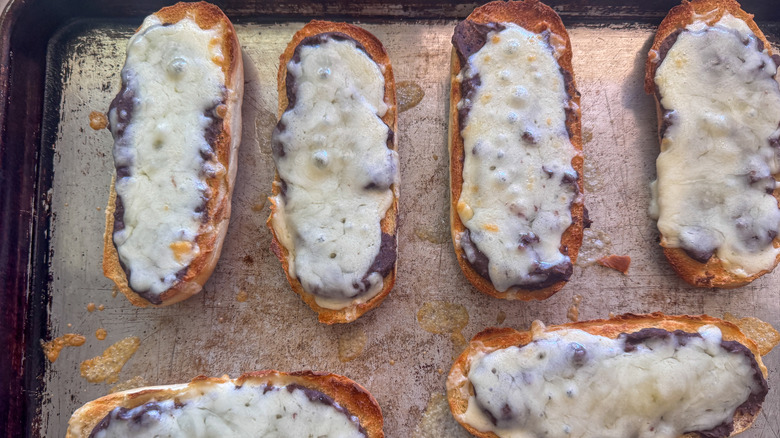molletes with melted cheese on sheet pan