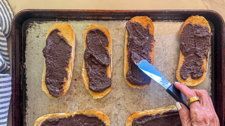 hand spreading bread with puree