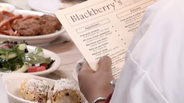 customer looking at Blackberry's menu with food on table