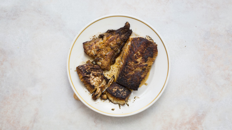 blackened cod on white plate