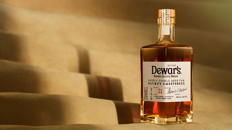 a bottle of Dewar's Double Double 21 against a tan background