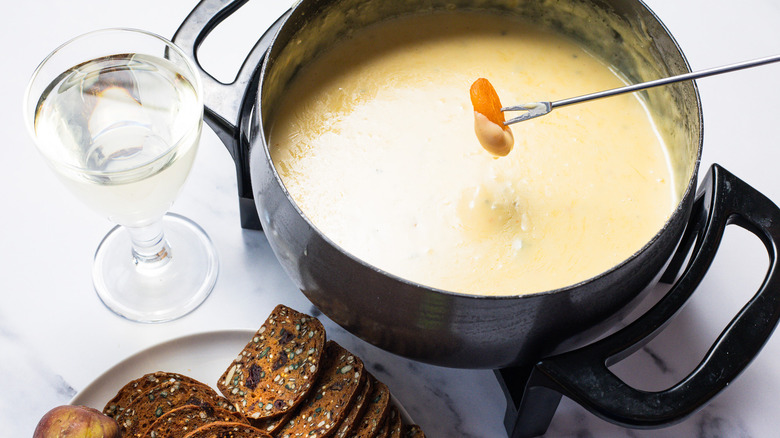 Dipping dried apricots into bleu cheese and honey fondue.