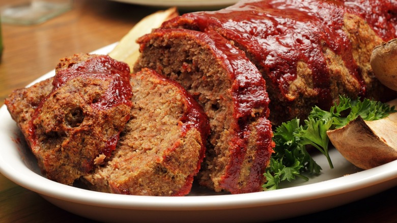 Glazed meatloaf slices with potato wedges on a plate