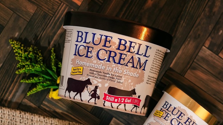 Half gallon and pint containers of Blue Bells Homemade in the Shade ice cream sitting on dark wood surface