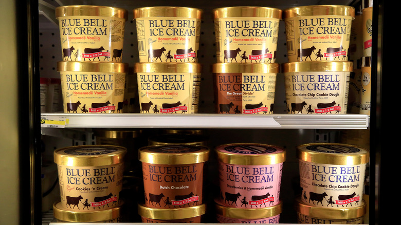 Pints of various Blue Bell ice creams inside freezer, including vanilla, strawberry, cookies /n cream, and chocolate flavors