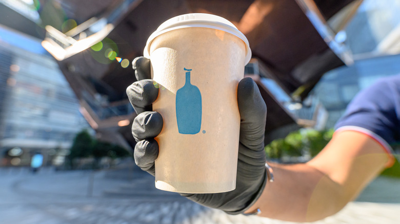 hand holding Blue Bottle cup