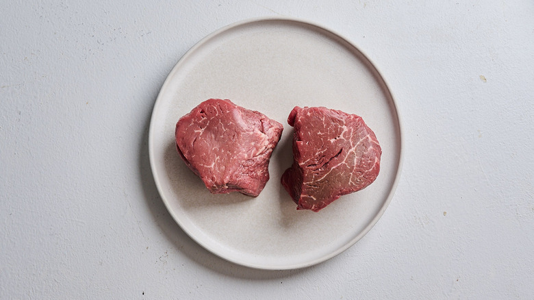 Raw steaks resting on a plate