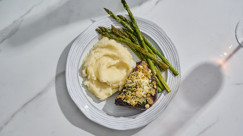 Serving steak on a plate with potatoes and asparagus