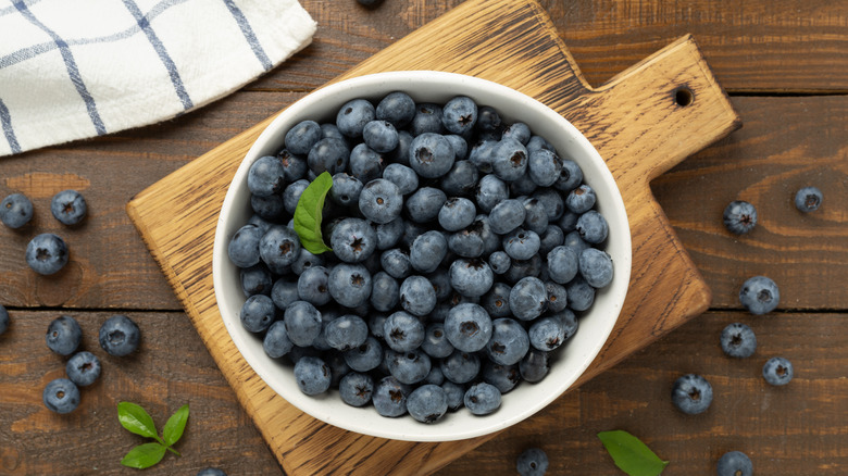 white bowl of blueberries with a tea towel