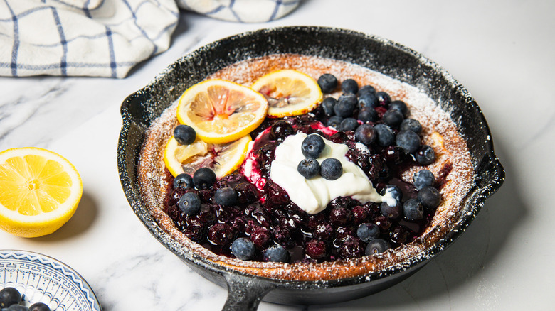 Blueberry lemon dutch baby pancake in cast iron pan.