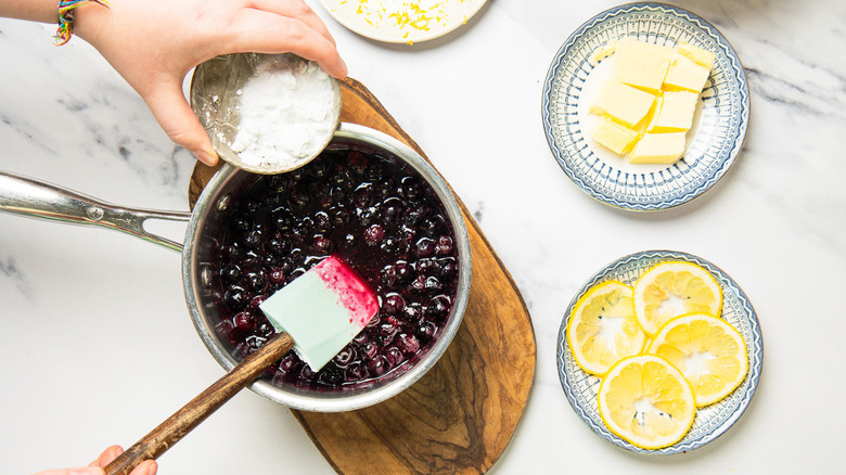 Adding cornstarch to saucepan.