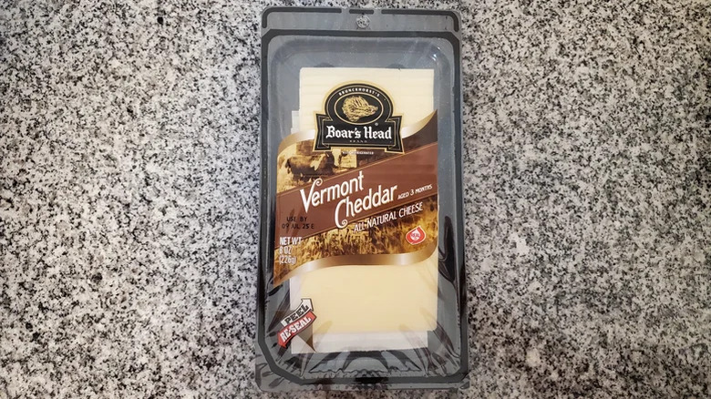 An unopened packet of Boar's Head Vermont Cheddar All Natural Cheese