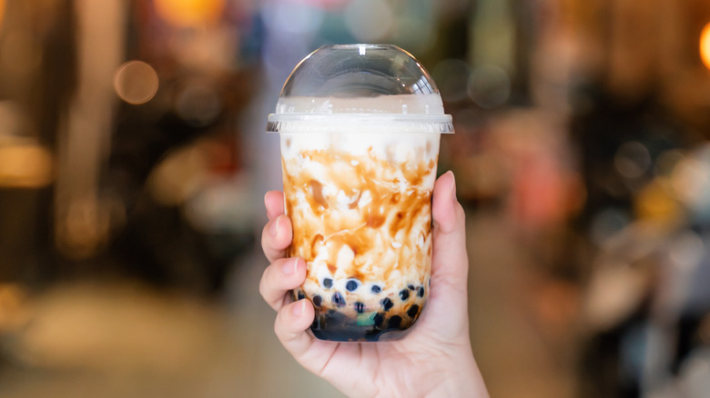 hand holding cup of brown sugar boba