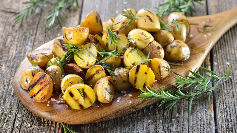 Grilled potatoes on a wooden serving board