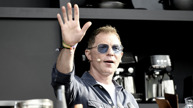 Bobby Flay waves during a cooking demonstration