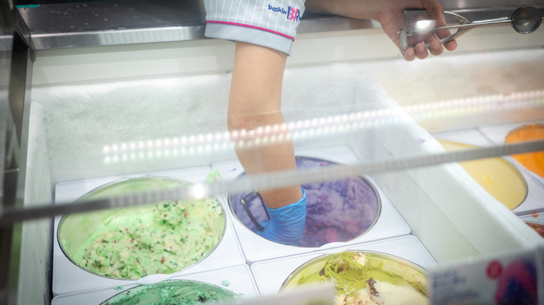 Hand reaching to scoop ice cream at Baskin-Robbins