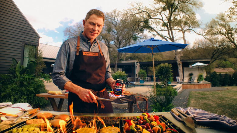 Bobby Flay grilling with Pepsi can