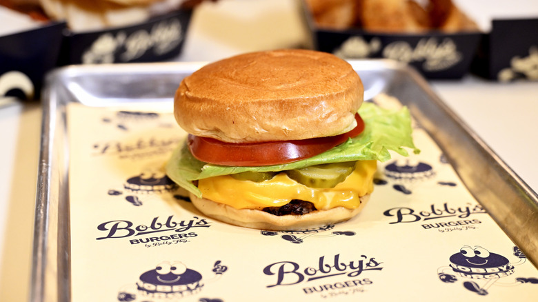 Bobby's burger on the platter with lettuce, tomatoes, and pickles