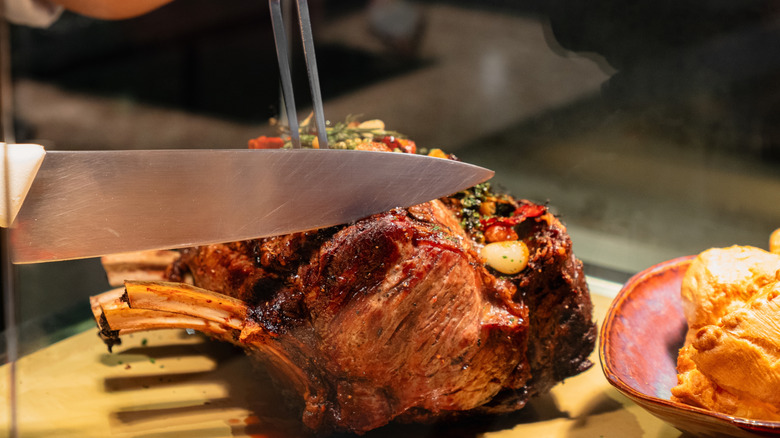 chef slicing prime rib on a cutting board