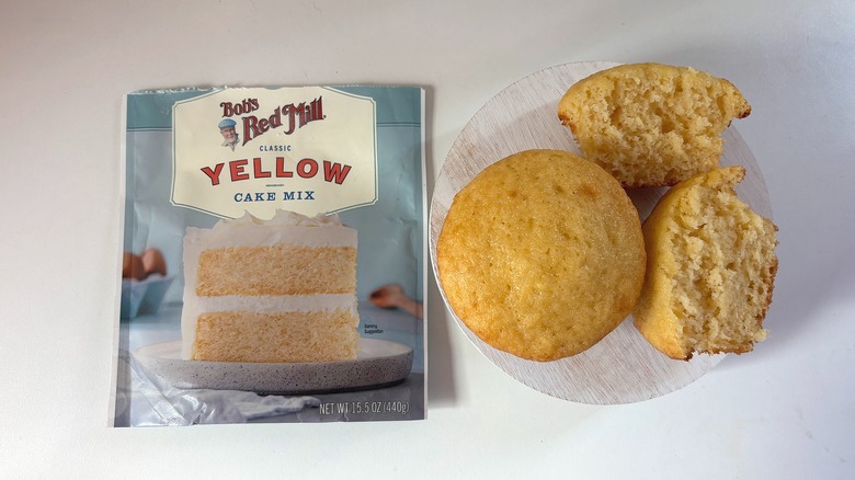 Bob's Red Mill yellow cake mix bag next to yellow cupcakes on white table