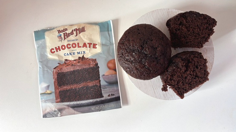 Bob's Red Mill chocolate cake mix bag next to chocolate cupcakes on white table