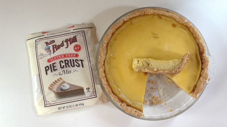 Bag of Bob's Red Mill Gluten Free pie crust mix on table next to custard pie