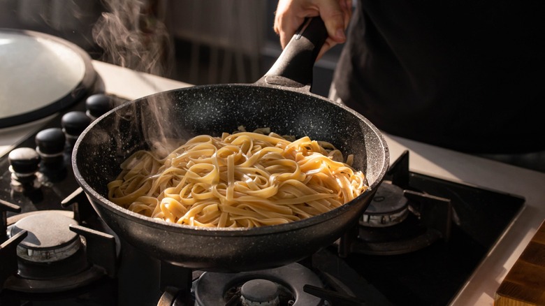 chef making pasta in wok