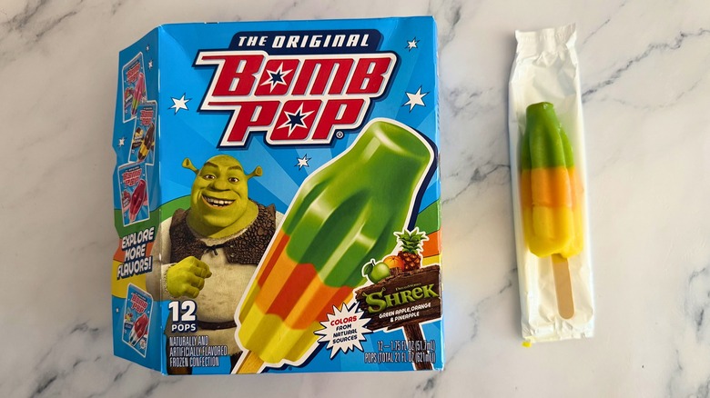 Box of Shrek Bomb Pops next to opened Bomb Pop on marble surface