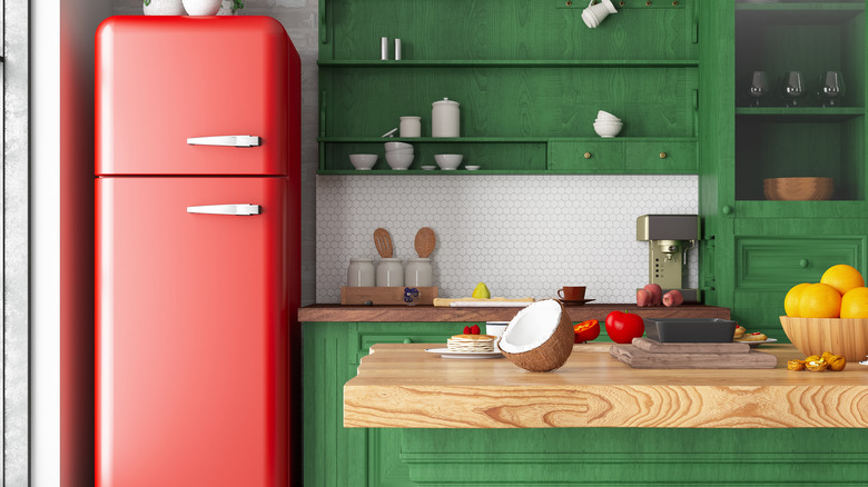 Kitchen with green cabinets and pink retro-style refrigerator