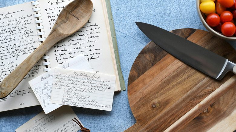 Handwritten recipe cards beside a kitchen knife