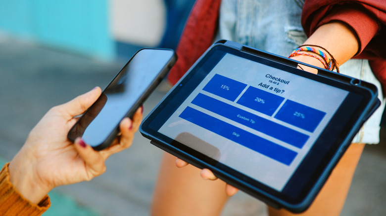 Person checking out with tip screen