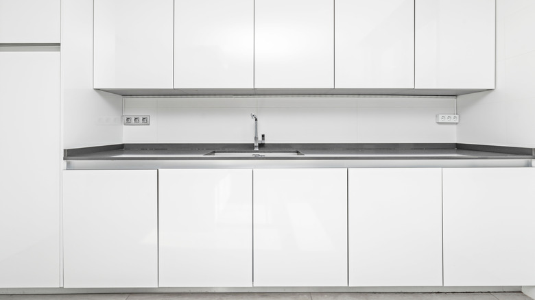 An all-white kitchen, with paneled major appliances, giving the entire kitchen a uniform and monochrome appearance