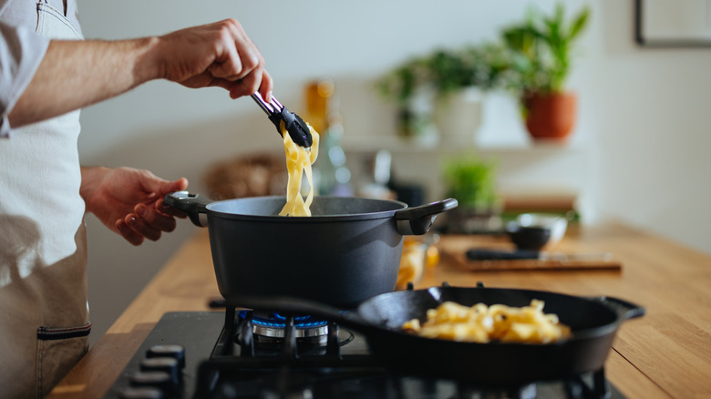 Home cook boiling pasta in a pot on the stove