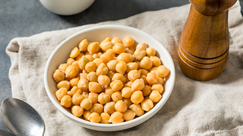 White bowl of chickpeas with pepper mill
