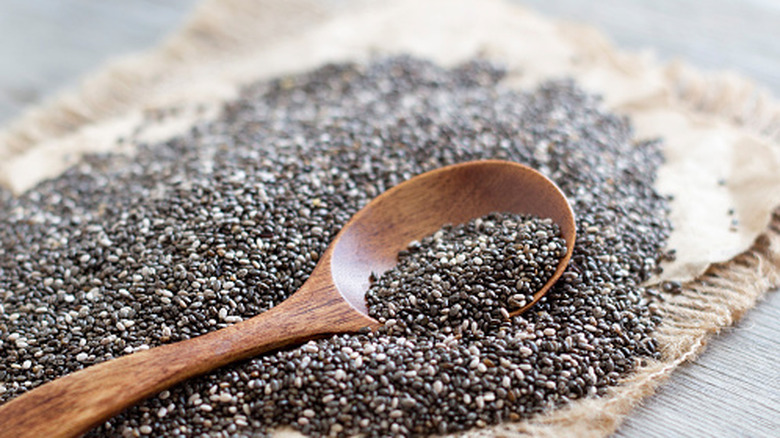 black and white chia seeds laid out with a wooden spoon