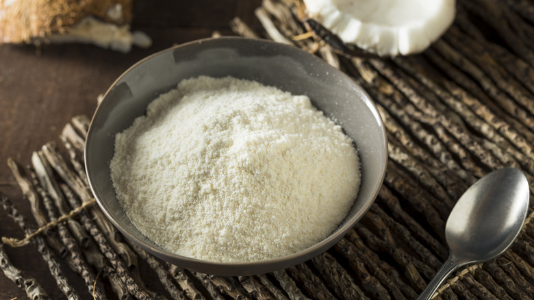 coconut flour in a gray dish on a rustic surface