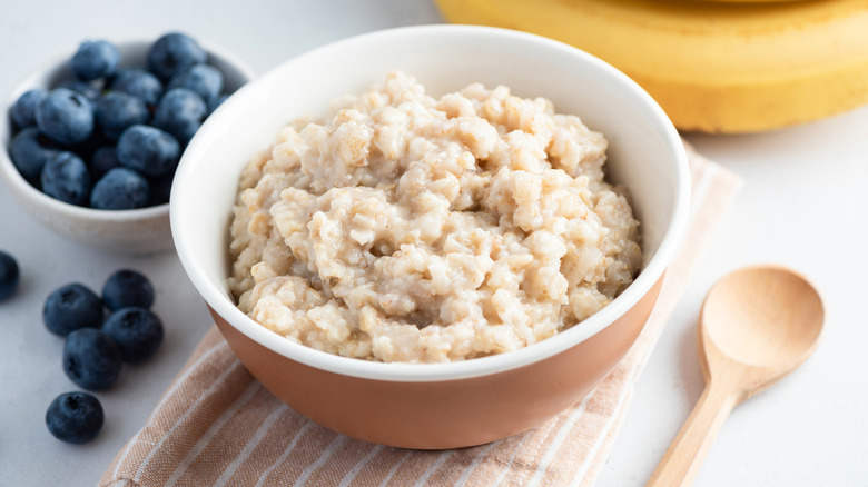 plain oatmeal in a bowl with a side of blueberries