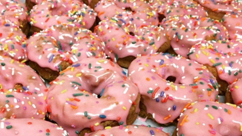 Pink frosted donuts with sugar sprinkles from Donuts With A Difference