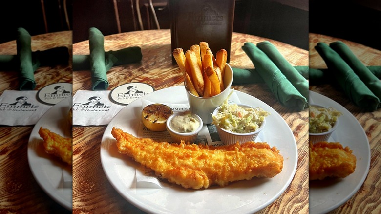 platter of fish and chips and coleslaw on a white plate with Emmets Pub & Restaurant logo napkins