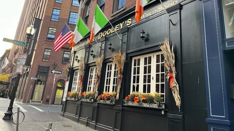 black painted facade of Irish pub with gold-emblazoned Mr. Dooley's sign with American and Irish flags