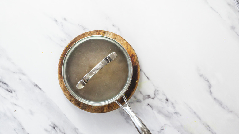 Lavender syrup steeping in covered saucepan.