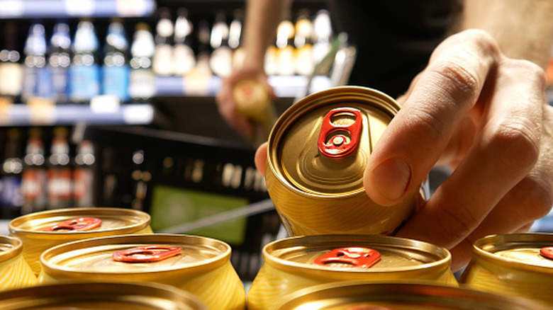 Close-up of a shopper buying beer cans