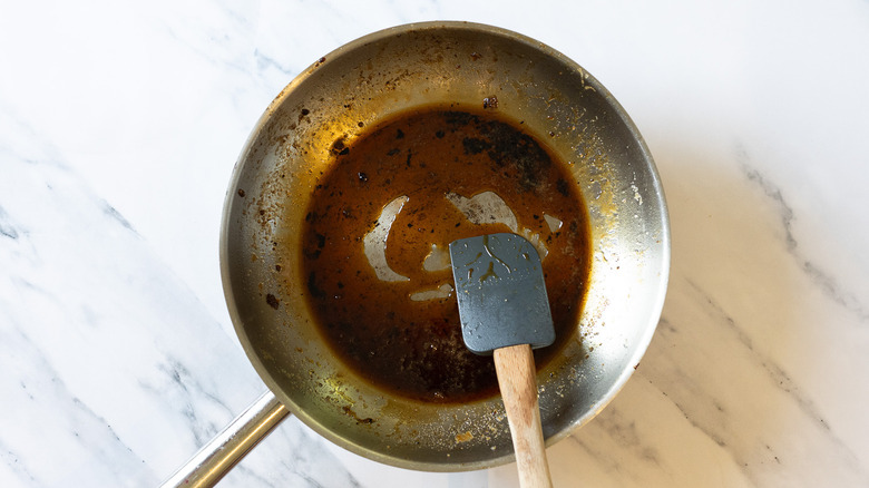 Spatula in pan with melted sugar and bourbon