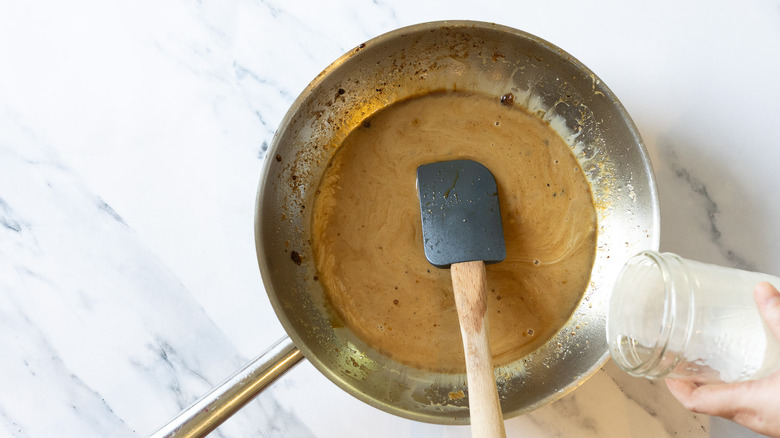 Spatula in pan with caramel sauce.