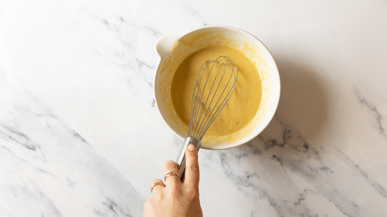 Whisking wet ingredients in bowl.