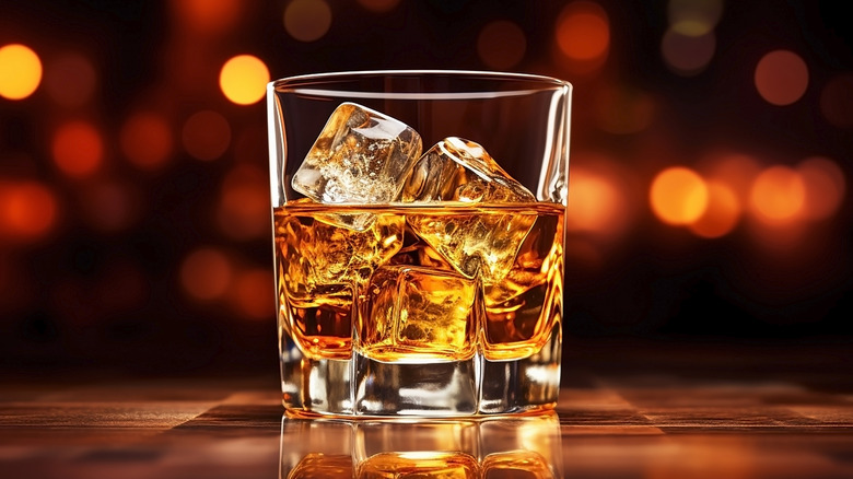 Glass of iced bourbon on top of a bar counter